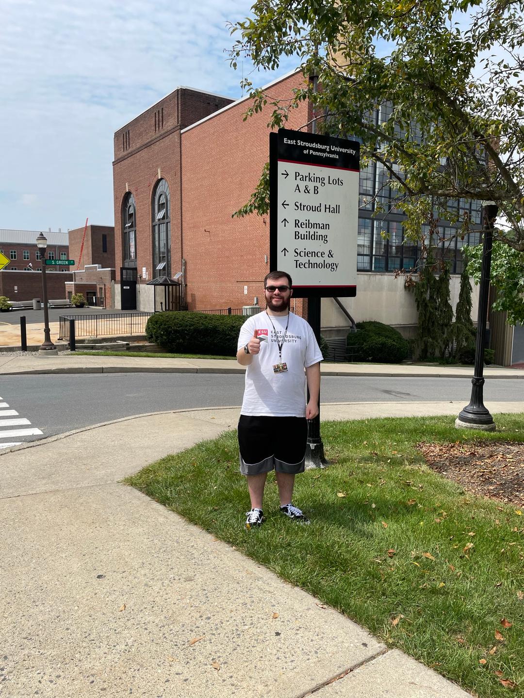 John standing next to a navigation sign on ESU's campus